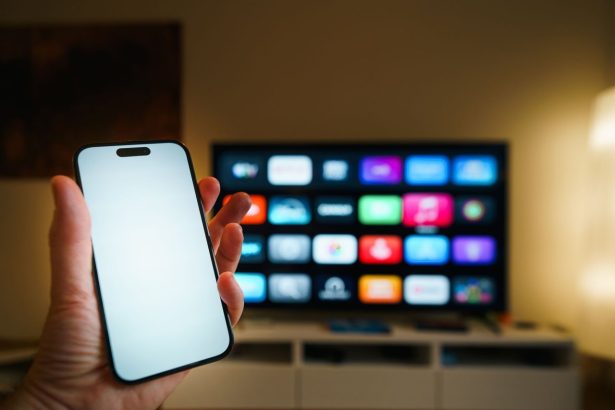 Smart TV exibindo aplicativos em uma sala de estar, com um smartphone em primeiro plano.