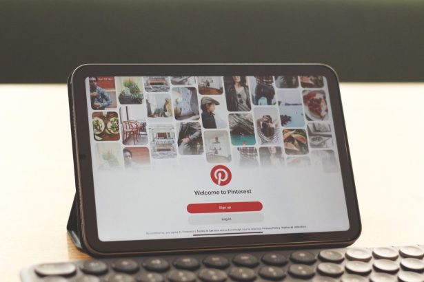 Tablet exibindo a página inicial do Pinterest sobre uma mesa com teclado.